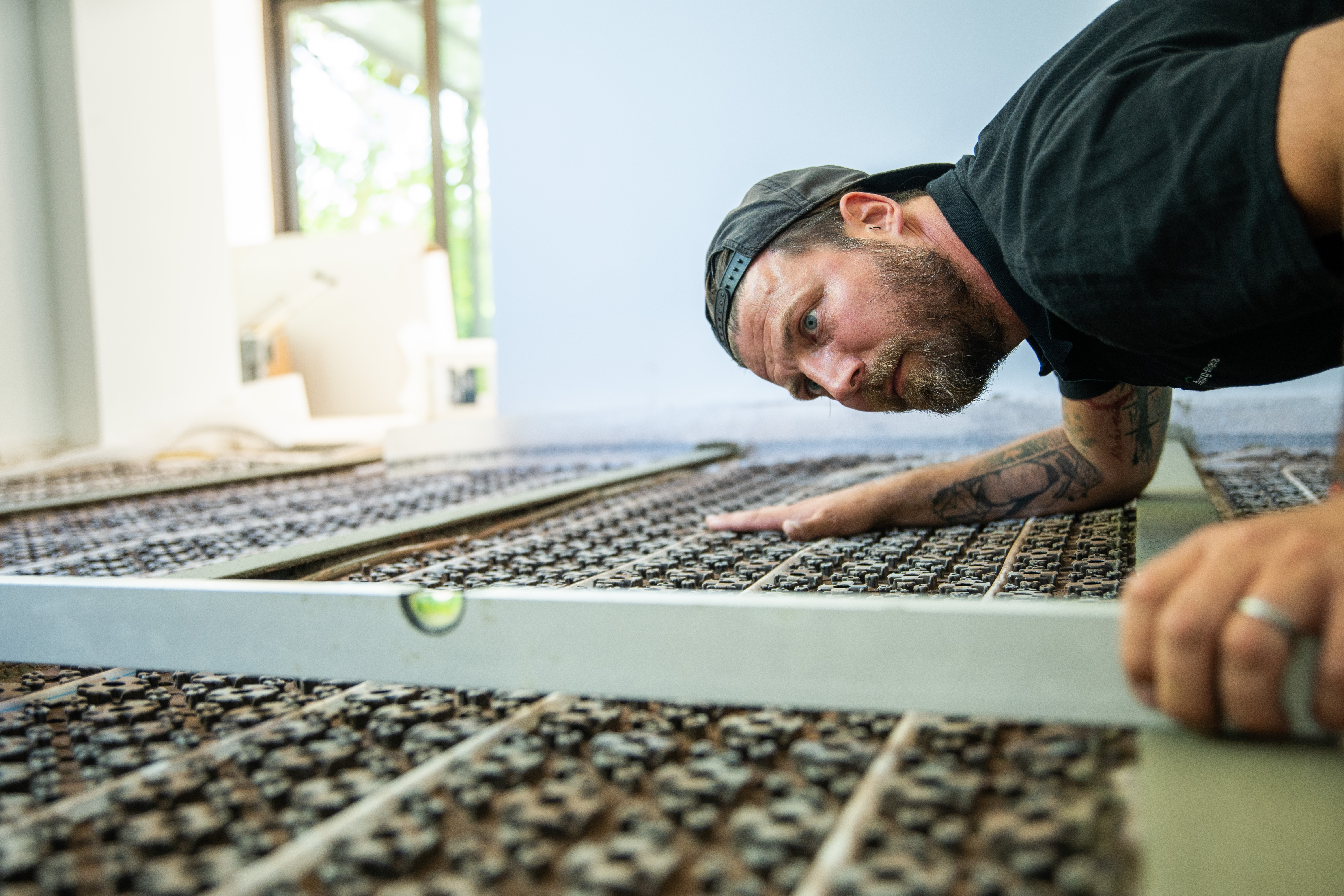 Zwei Handwerker montieren eine Trockenbaudecke als Teil eines professionellen Sanierungsprojekts, mit Fokus auf Teamarbeit und Fachkompetenz.